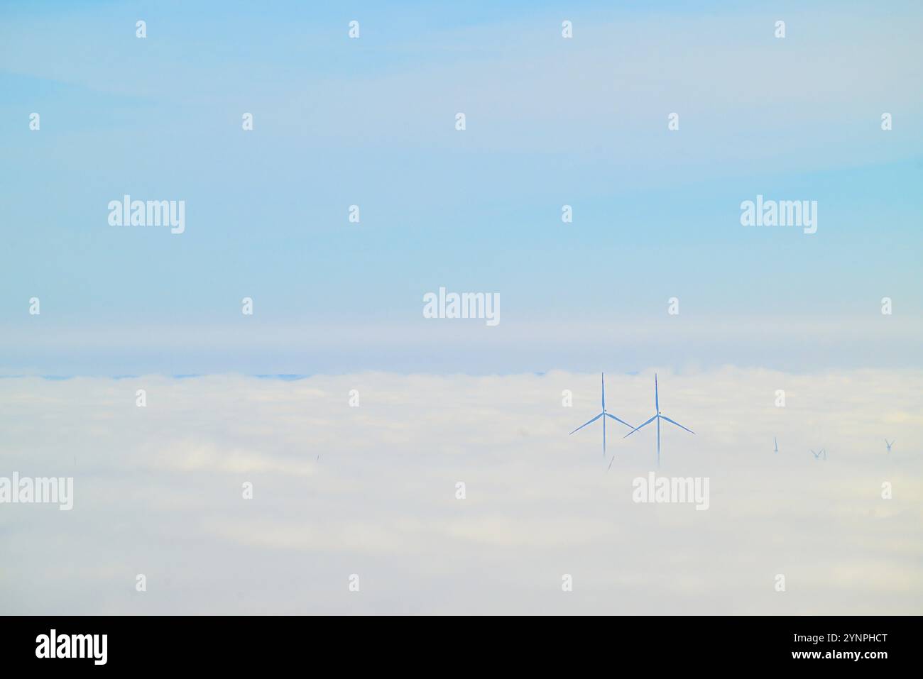 I due mulini a vento in nubi dense contro un cielo nuvoloso Foto Stock