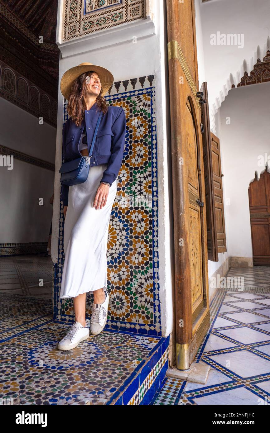 Giovane donna dai capelli scuri in Navy Blazer e gonna bianca in posa al Palazzo Bahia di Marrakech, Marocco Foto Stock