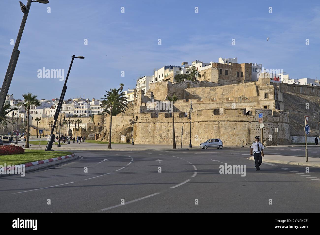 Muro di Tangeri con un poliziotto random che cammina per strada in una giornata di sole Foto Stock