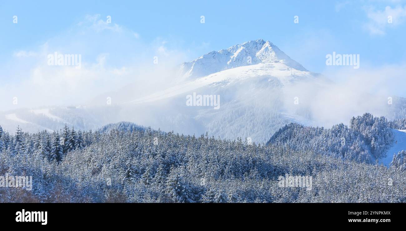 Bansko, Bulgaria, località sciistica sullo sfondo con vista panoramica sulle piste da sci, montagna innevata, nebbia e cielo azzurro Foto Stock