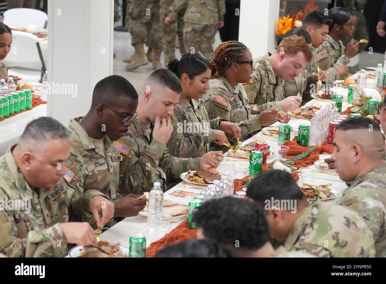 Eagle Pass Texas, USA, novembre 26 2024: Soldati in uniforme della Guardia Nazionale del Texas e soldati del Dipartimento di pubblica sicurezza del Texas gustati una cena del Ringraziamento nella sala da pranzo della base operativa avanzata per l'operazione Lone Star vicino al confine tra Texas e Messico. I soldati e le truppe stanno contribuendo a far rispettare la sicurezza e a frenare il flusso di immigrati clandestini nello Stato. Crediti: Bob Daemmrich/Alamy Live News Foto Stock