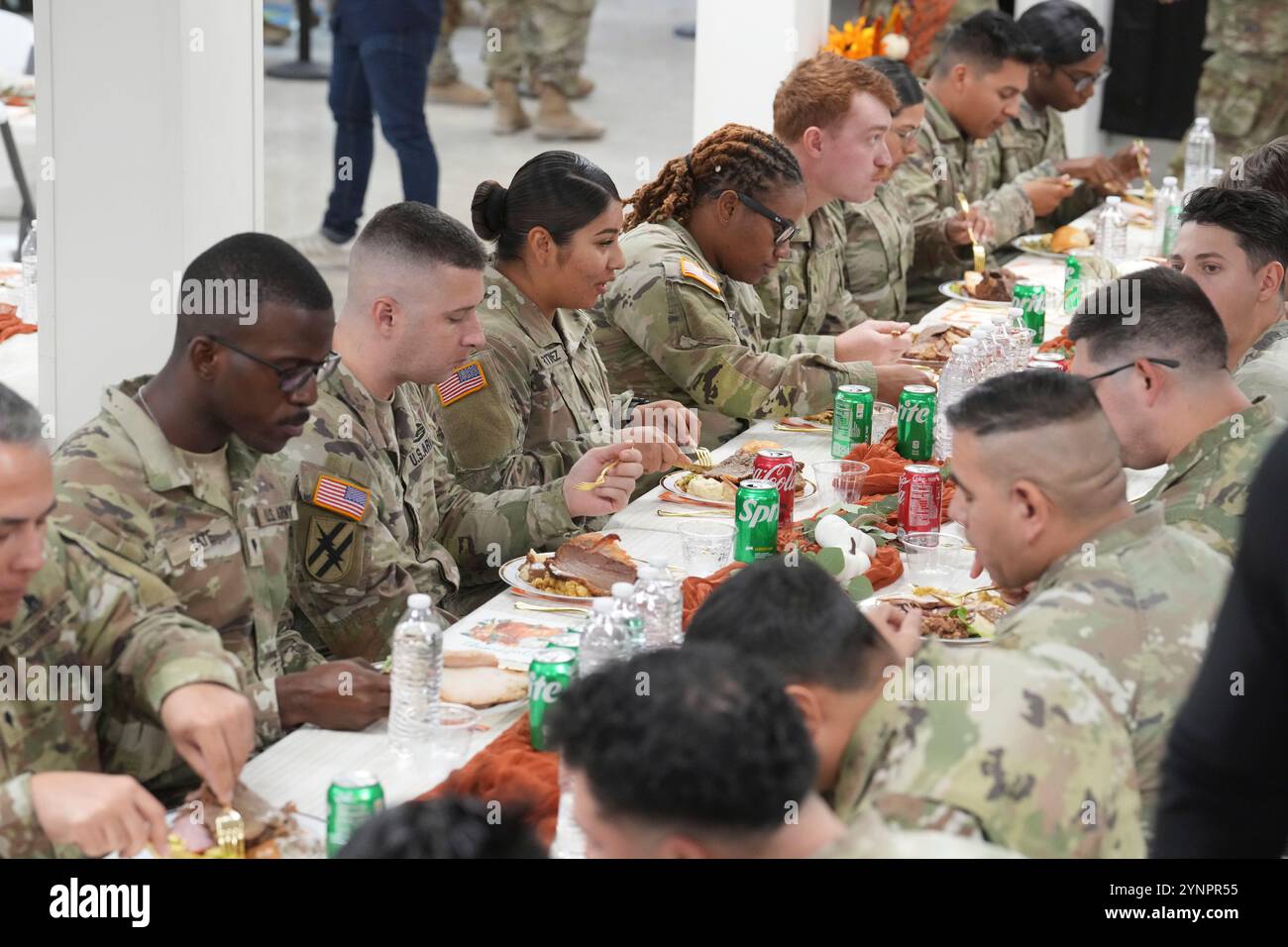 Eagle Pass Texas, USA, novembre 26 2024: Soldati in uniforme della Guardia Nazionale del Texas e soldati del Dipartimento di pubblica sicurezza del Texas gustati una cena del Ringraziamento nella sala da pranzo della base operativa avanzata per l'operazione Lone Star vicino al confine tra Texas e Messico. I soldati e le truppe stanno contribuendo a far rispettare la sicurezza e a frenare il flusso di immigrati clandestini nello Stato. Crediti: Bob Daemmrich/Alamy Live News Foto Stock