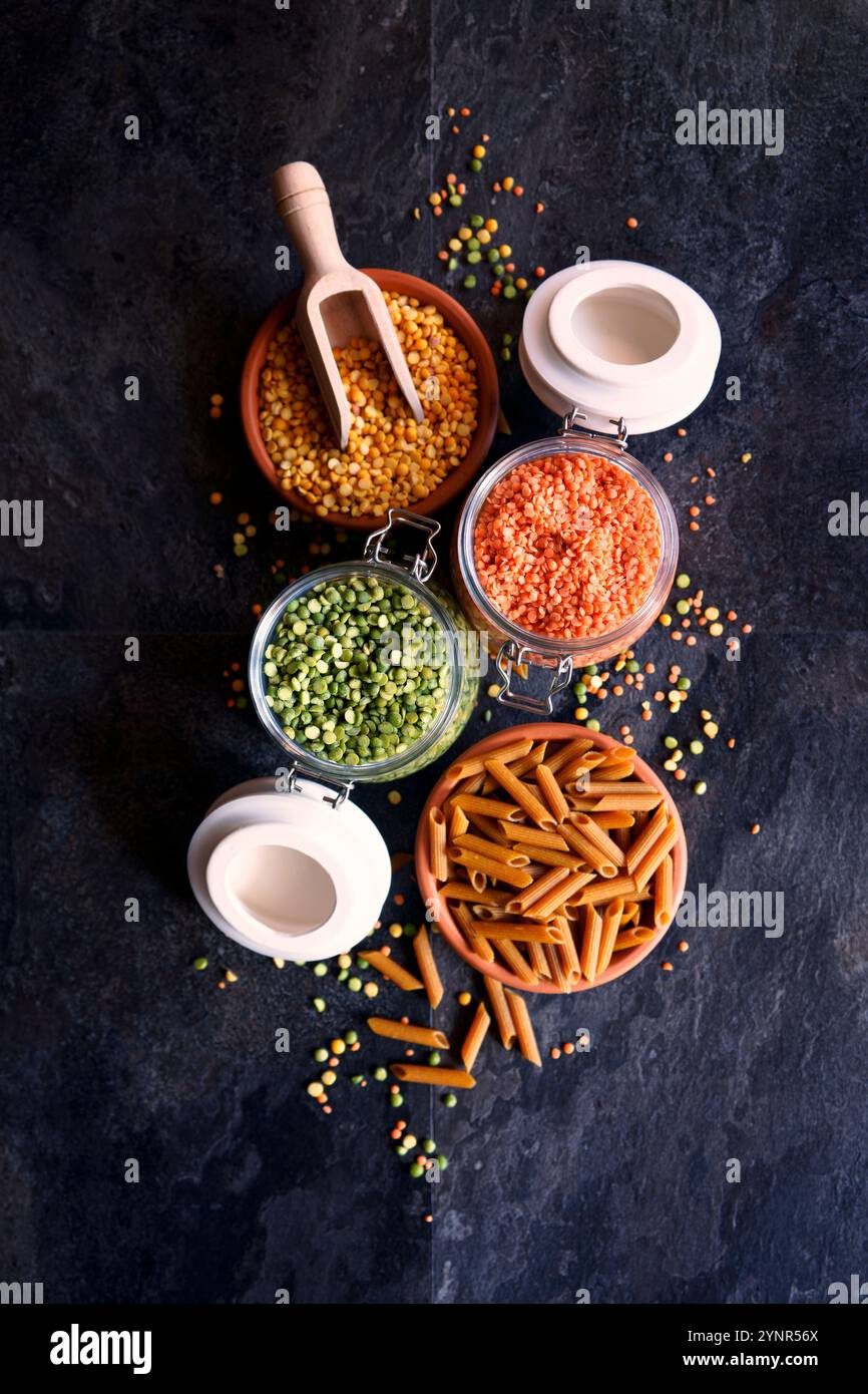 Piselli sciroppati secchi gialli e verdi, lenticchie rosse e pasta a base di legumi per una dieta alimentare completa a base vegetale. Foto Stock