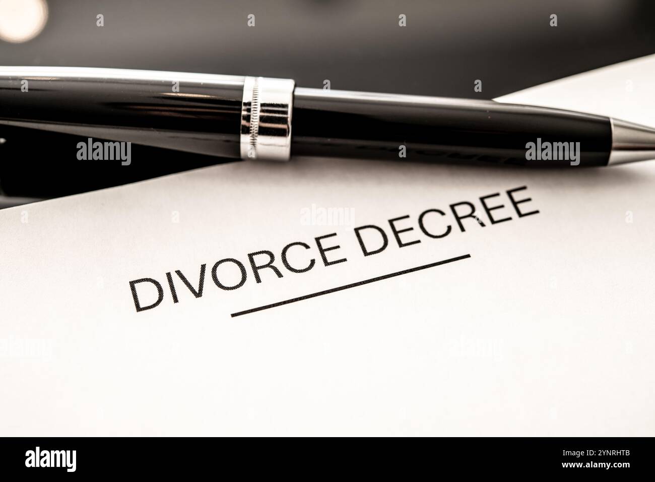 Primo piano di un decreto di divorzio con una penna stilografica, che enfatizza la separazione legale, lo scioglimento coniugale, la documentazione del tribunale e il viaggio emotivo di Foto Stock