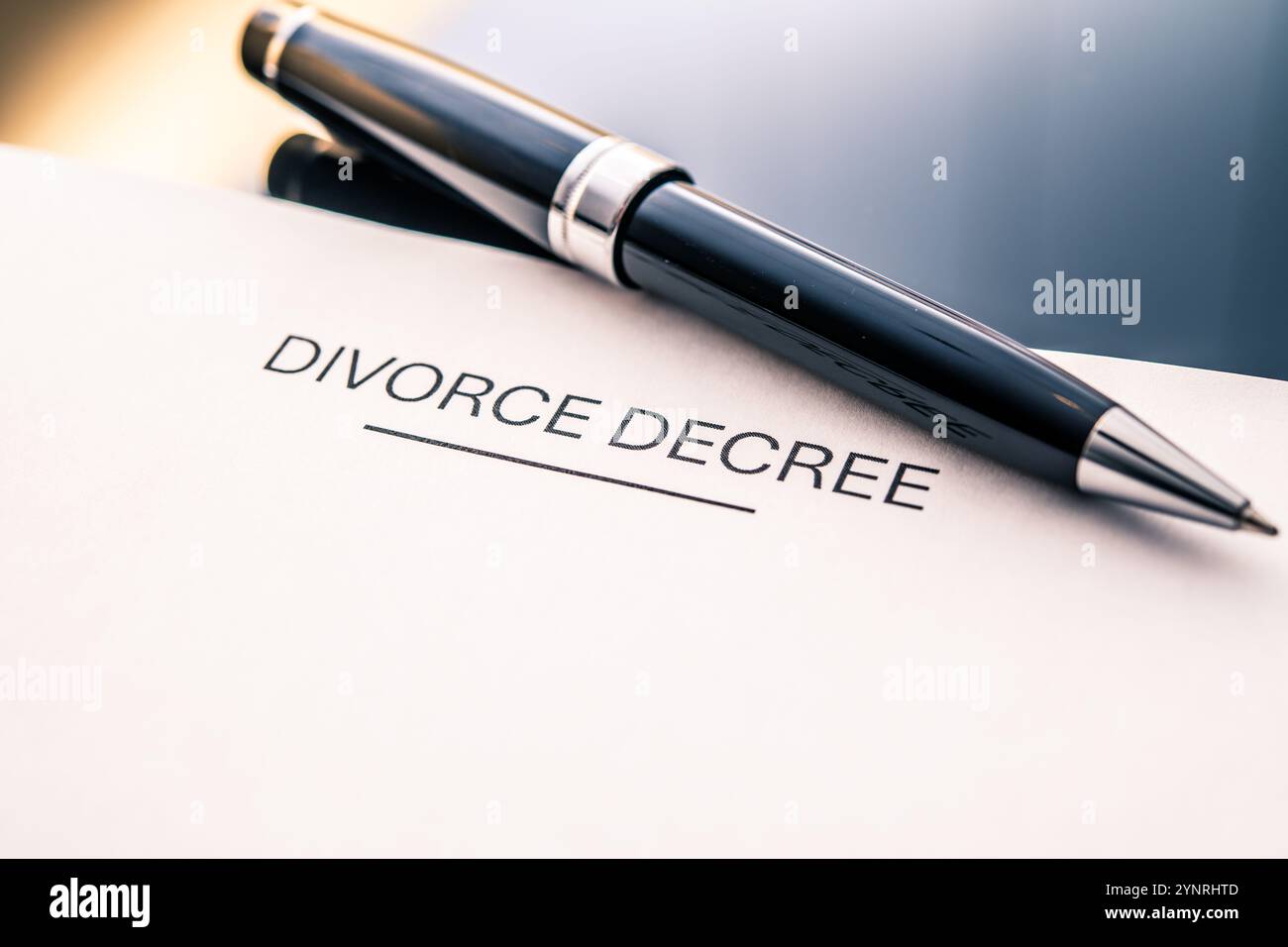 Documento del decreto di divorzio accanto a una penna stilografica che rappresenta la separazione legale, il diritto di famiglia, l'impatto emotivo, il processo di divorzio e la documentazione del tribunale Foto Stock