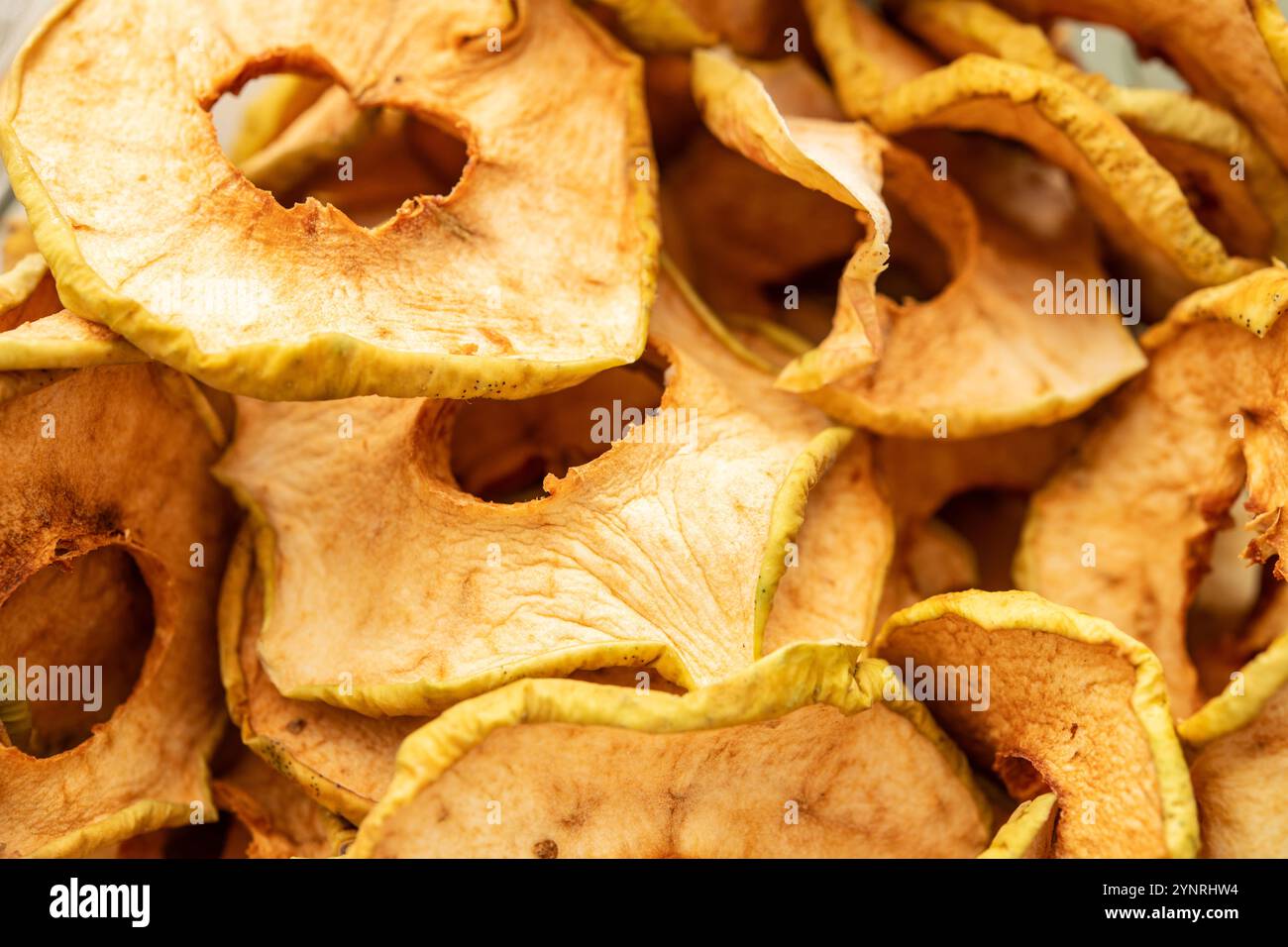 Primo piano di fette di mele secche, ideali per spuntini e ricette attente alla salute. Mostra la consistenza, il colore e i benefici nutrizionali del fr disidratato Foto Stock
