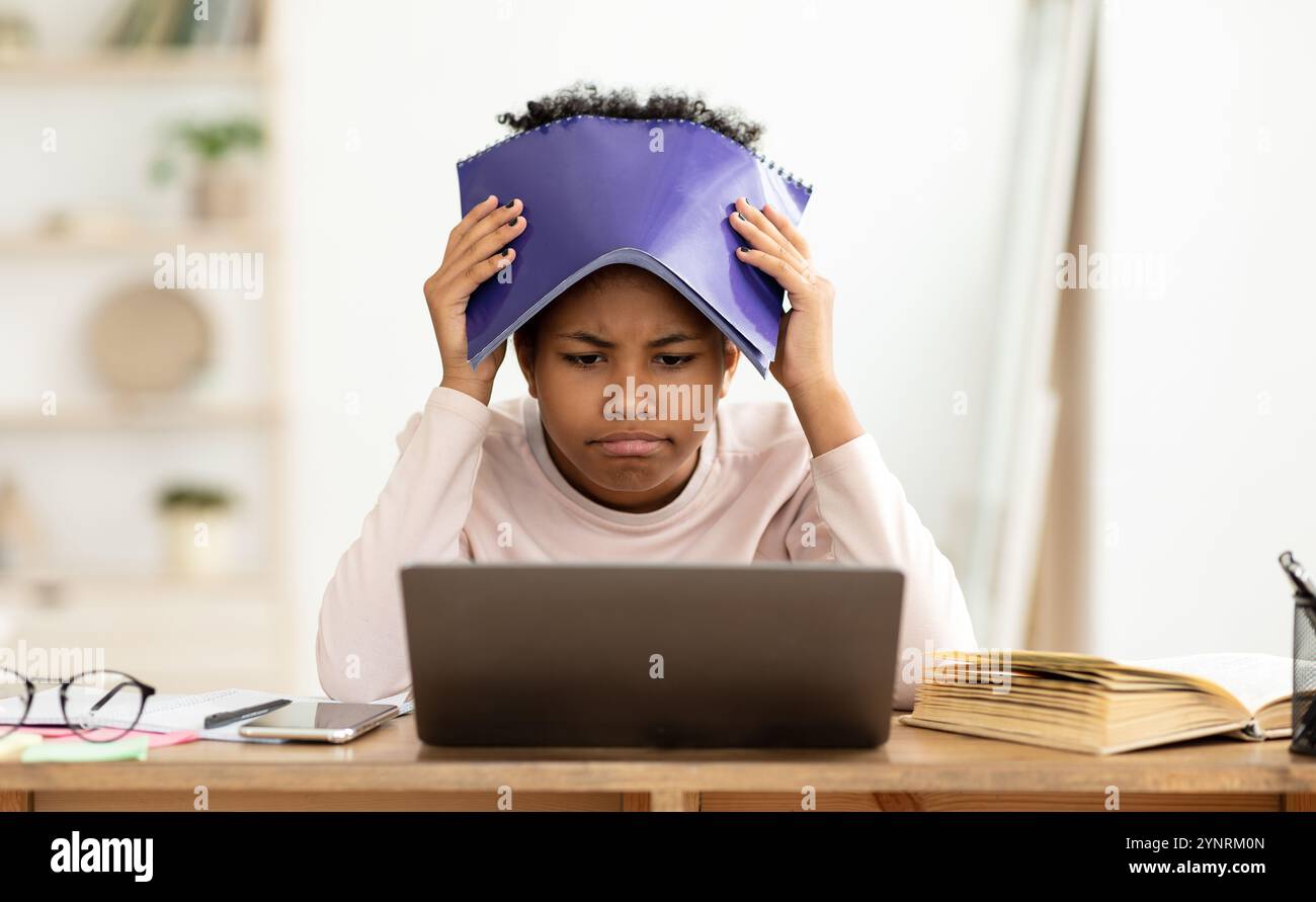 Kid frustrato ottenendo il grado difettoso durante la classe in linea a casa Foto Stock