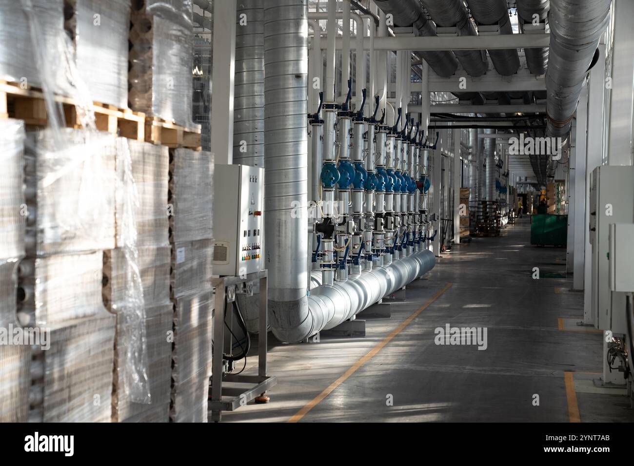 Passaggio tra serre con stoccaggio e riscaldamento degli imballaggi, sistema di tubazioni dell'acqua e scatola fusibili Foto Stock