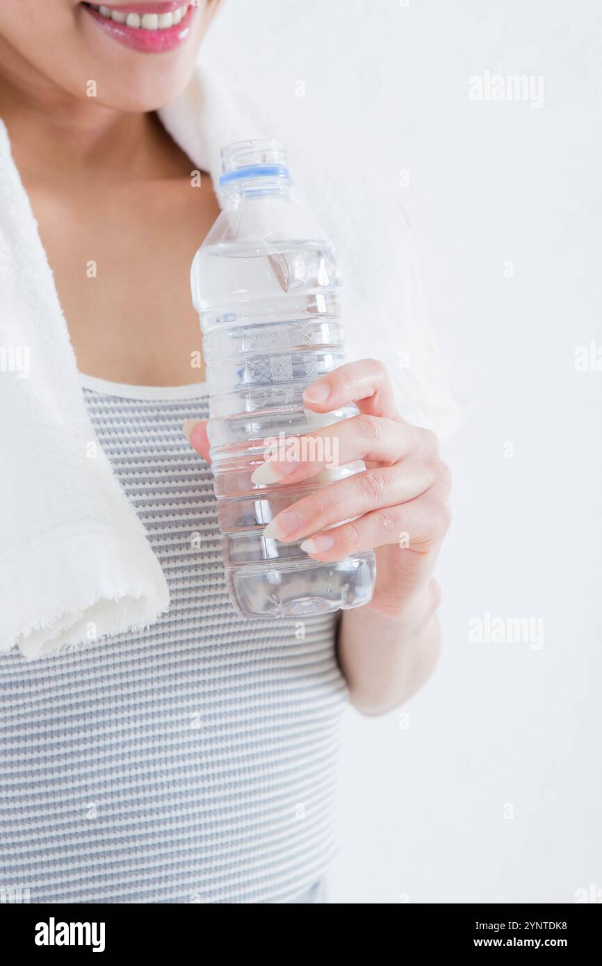 Donna con in mano una bottiglia di plastica Foto Stock
