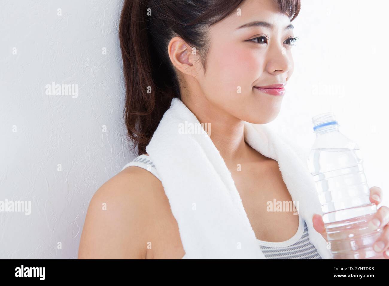 Donna con in mano una bottiglia di plastica Foto Stock