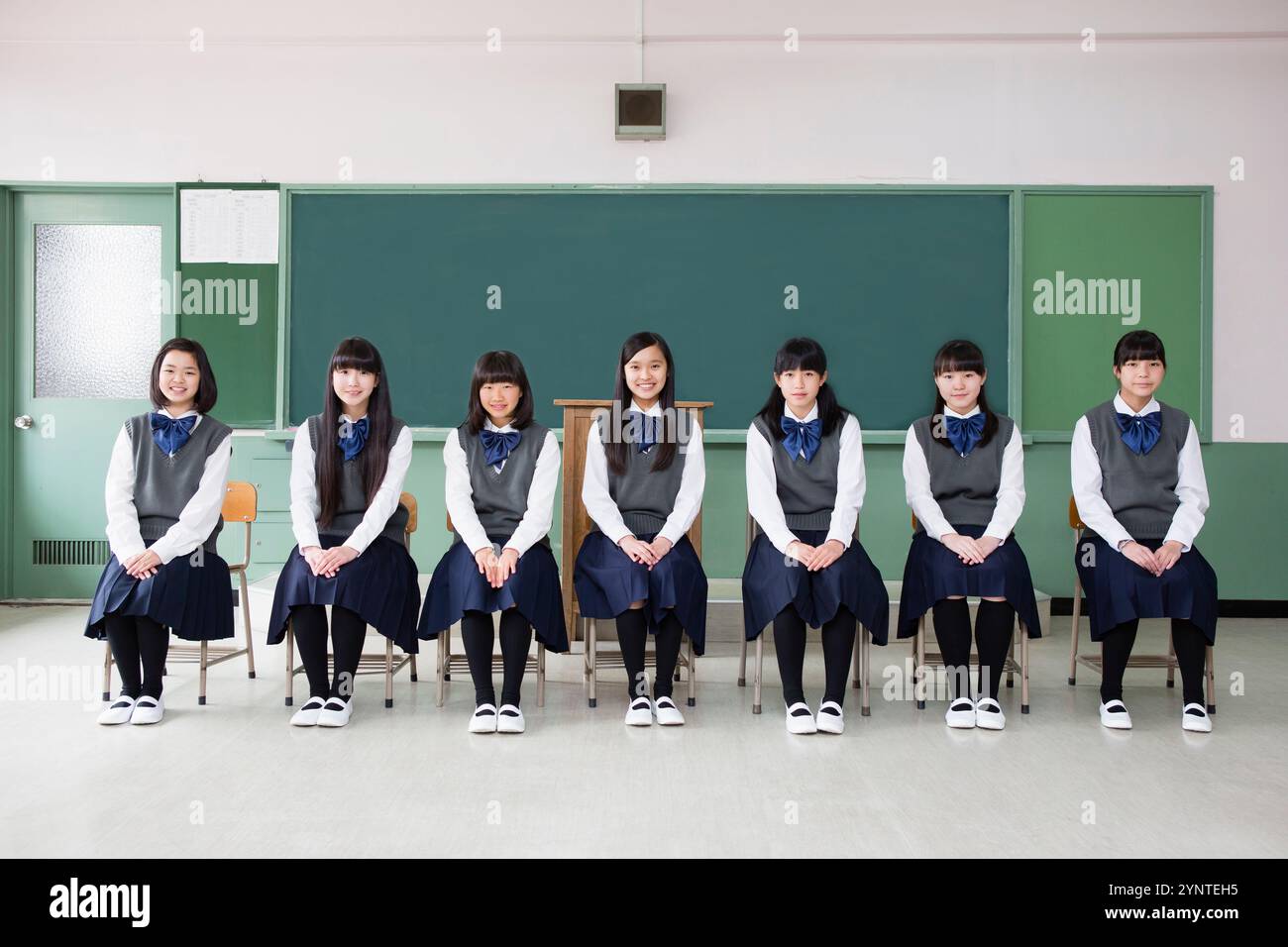 Studentessa seduta su una sedia di fila in una classe Foto Stock