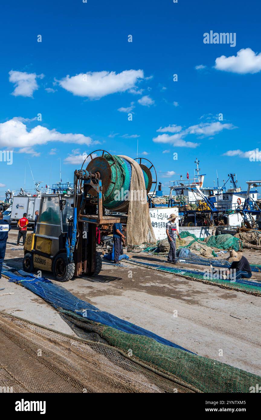 Sfax, Tunisia - 12 novembre 2024: Uomini che lavorano nel più grande porto peschereccio della Tunisia. Foto Stock