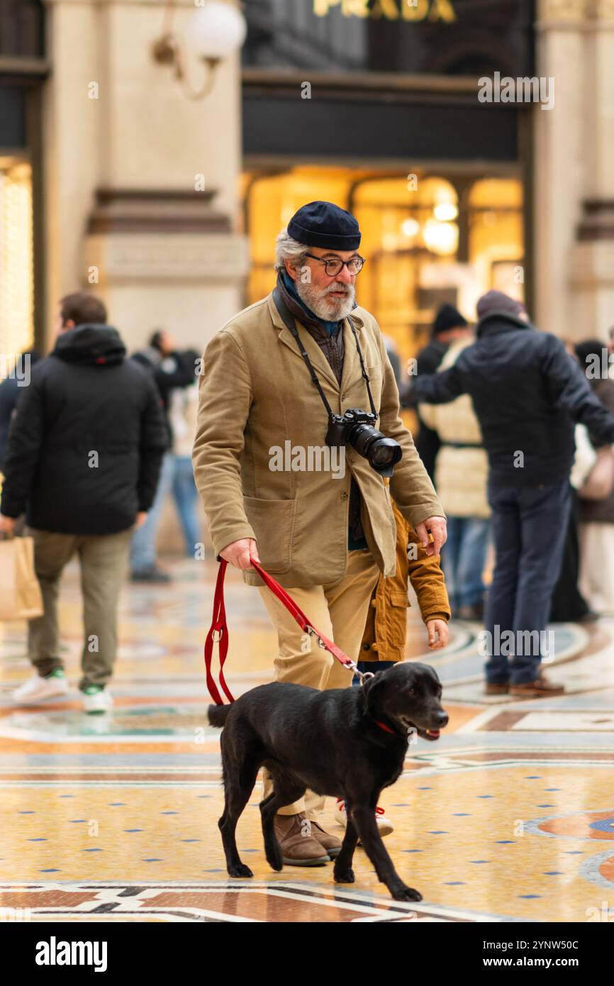 Milano, Italia - 18.12.2022: Uomo che cammina con il cane nella Galleria di Vittorio Emanuele Foto Stock