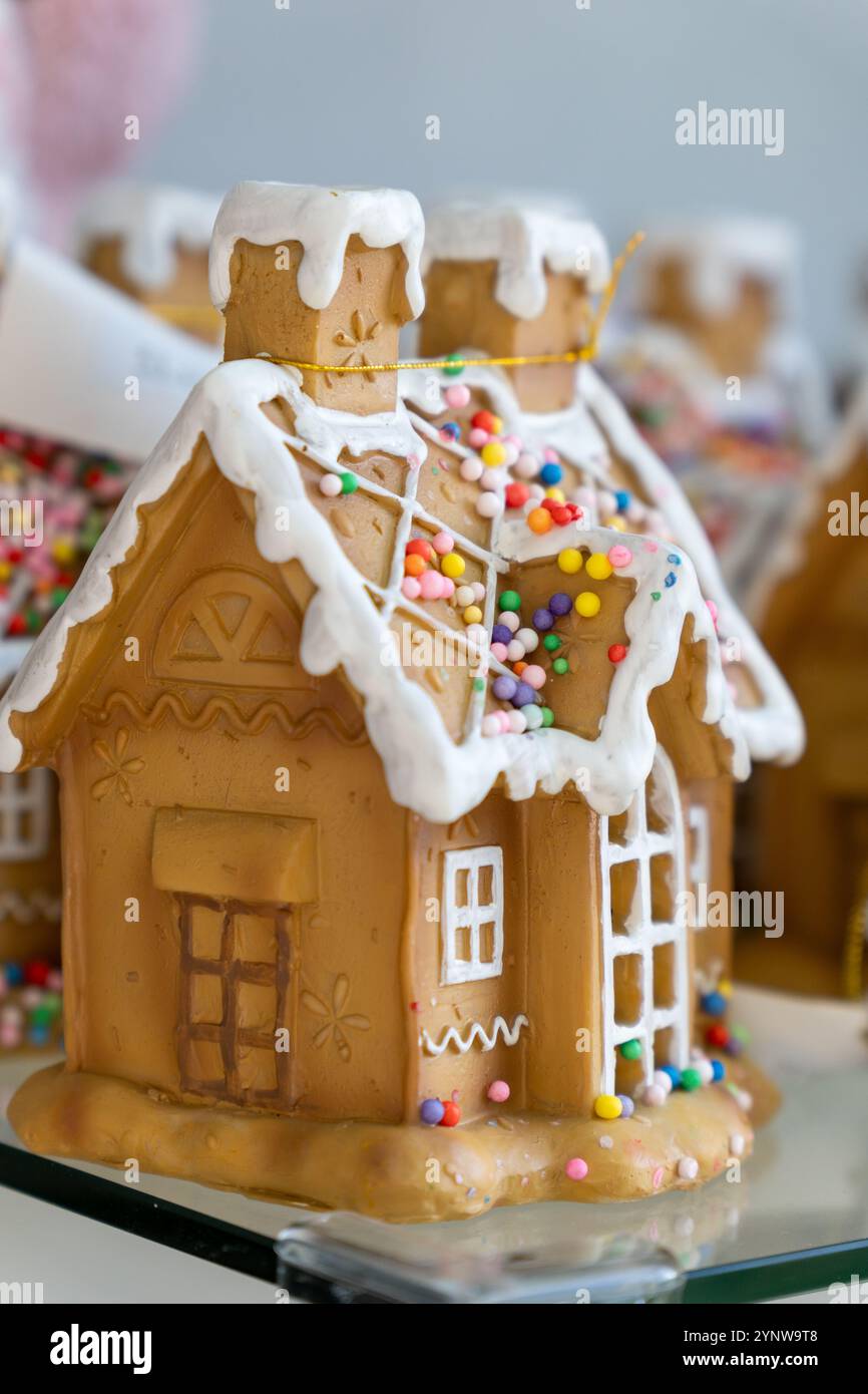 Un primo piano di una famiglia che decora una casa di pan di zenzero con glassa e caramelle. Foto Stock