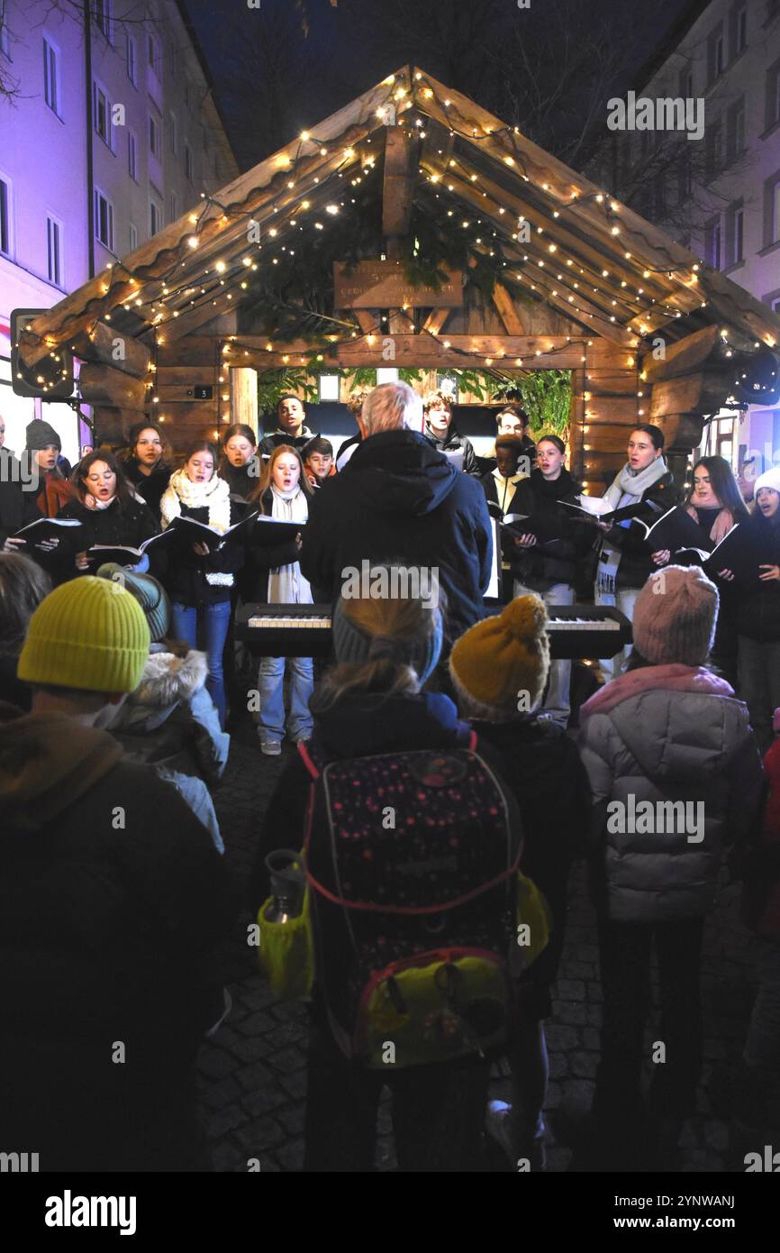 VOR der Krippe Jugendchor JHC Singschule Pfarrverband Haidhausen Muenchen 26,11 2024 Weissenburger Platz Haidhauser Weihnachtsmarkt Eroeffnung Muenchen *** di fronte al presepe Coro giovanile JHC Singschule Pfarrverband Haidhausen Monaco di Baviera 26 11 2024 Weissenburger Platz Haidhauser inaugurazione del mercato natalizio Monaco di Baviera Monaco di Baviera Monaco di Baviera Foto Stock