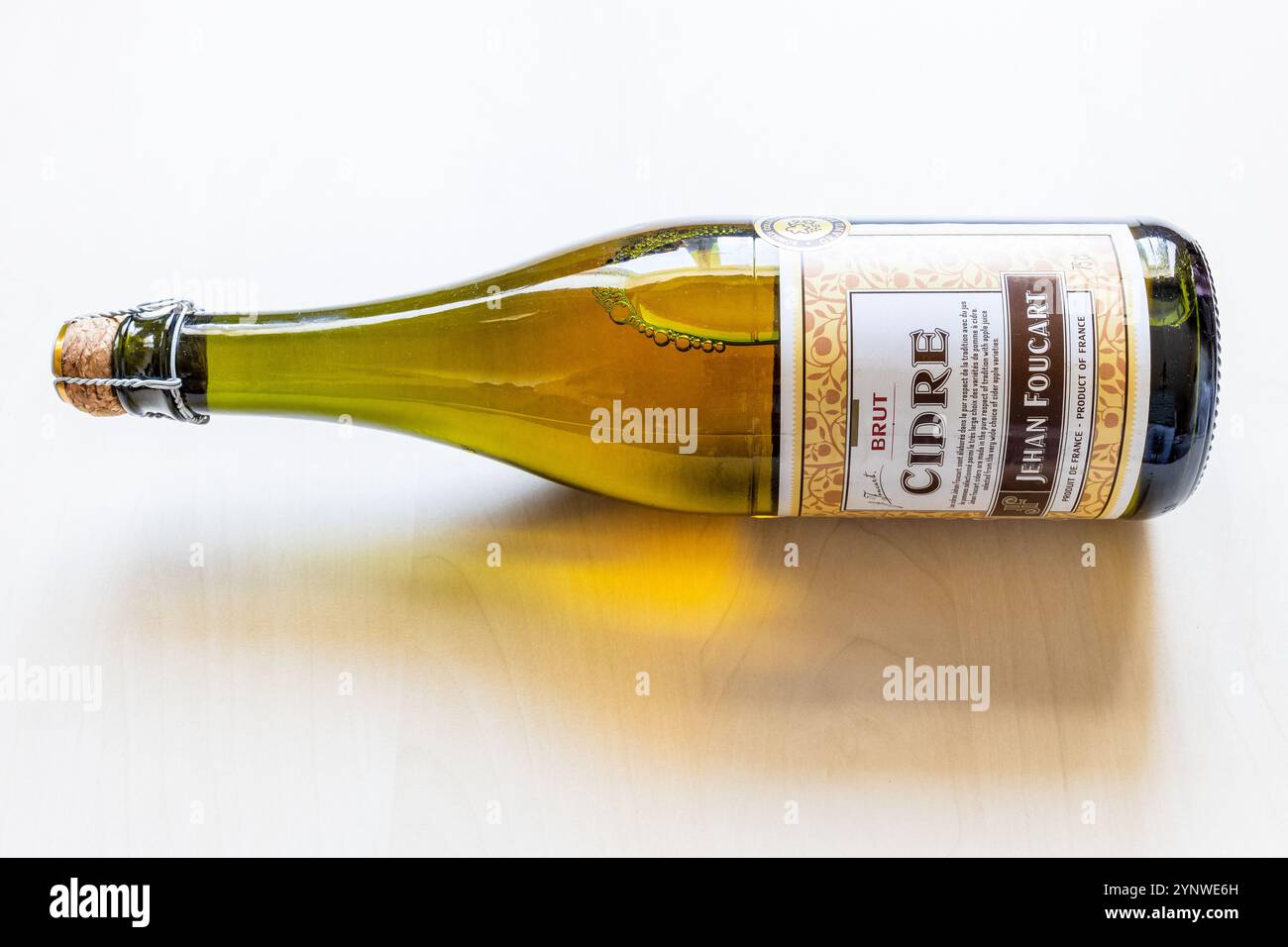 Mosca, Russia - 1° ottobre 2024: Bottiglia di vetro di sidro francese Jehan Foucart brut giace su una tavola di legno marrone chiaro Foto Stock