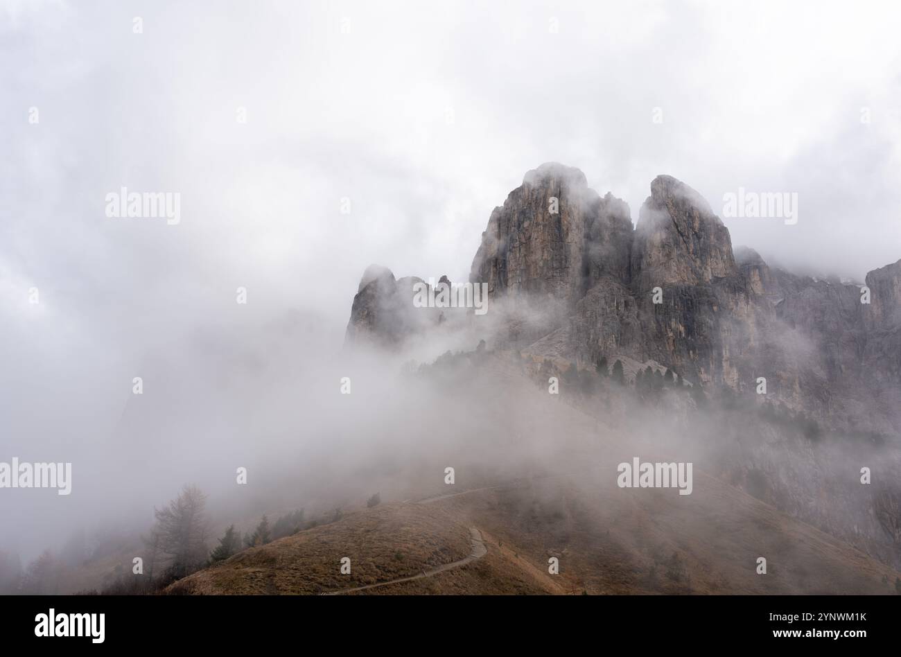 Condizioni nebbiose sul passo Gardena, con un sentiero che conduce ad un suggestivo paesaggio montano Foto Stock