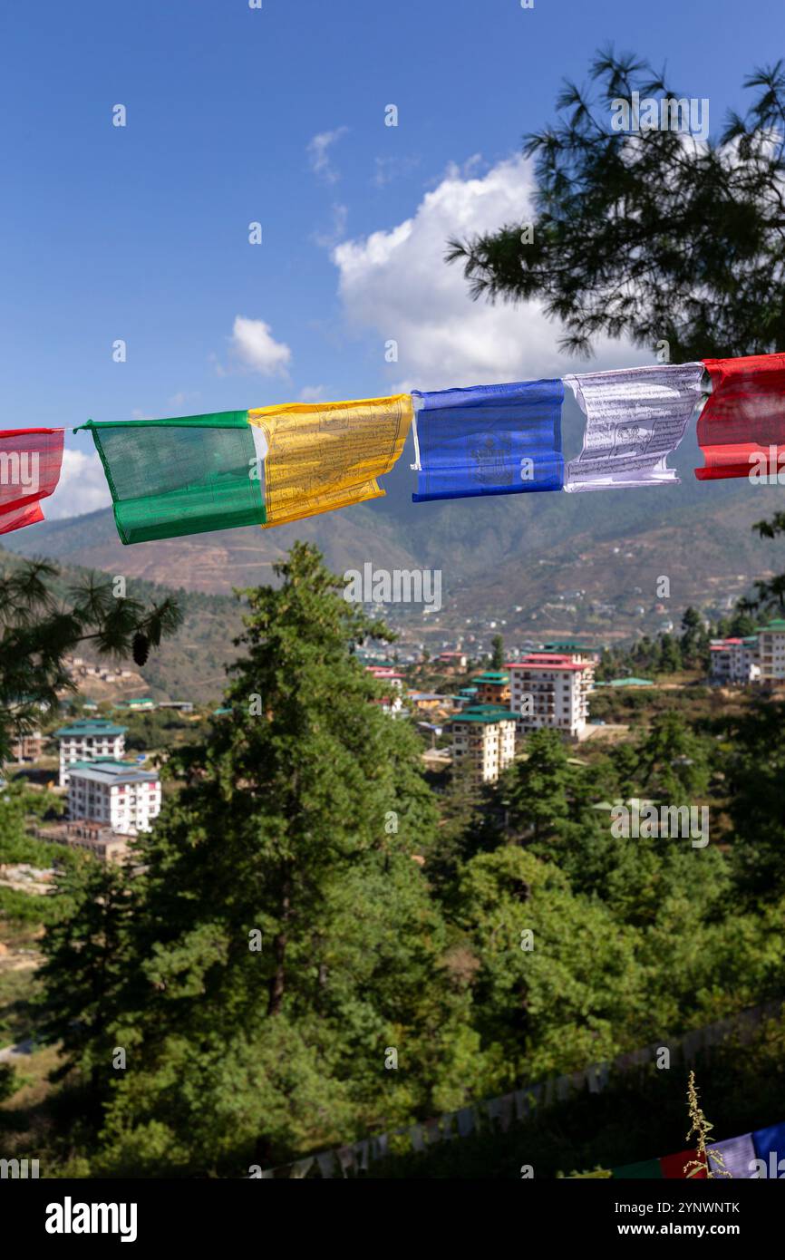 Una vivace mostra di bandiere di preghiera colorate che sventolano nel vento sullo sfondo di un cielo azzurro Foto Stock