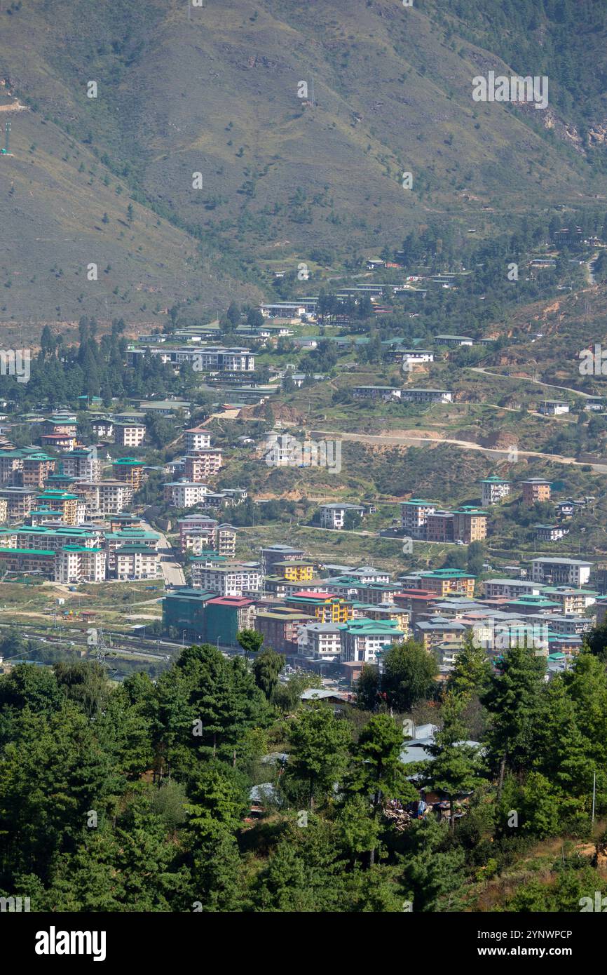 Lo sviluppo urbano della città, con file di case ed edifici che si arrampicano sulla collina, Thimphu, Bhutan. Foto Stock