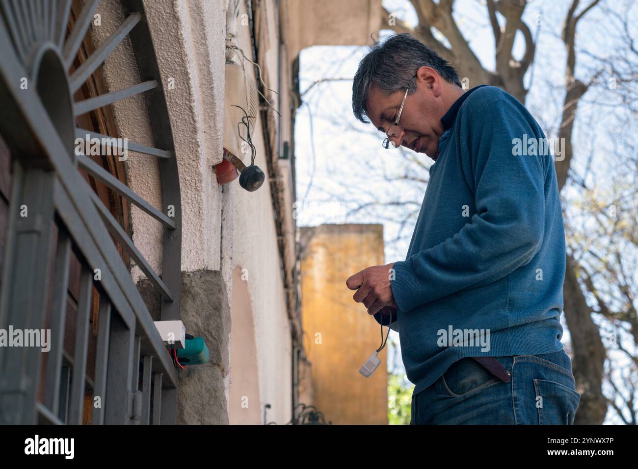 Tecnico che installa la cellula fotoelettrica in una casa. Foto Stock