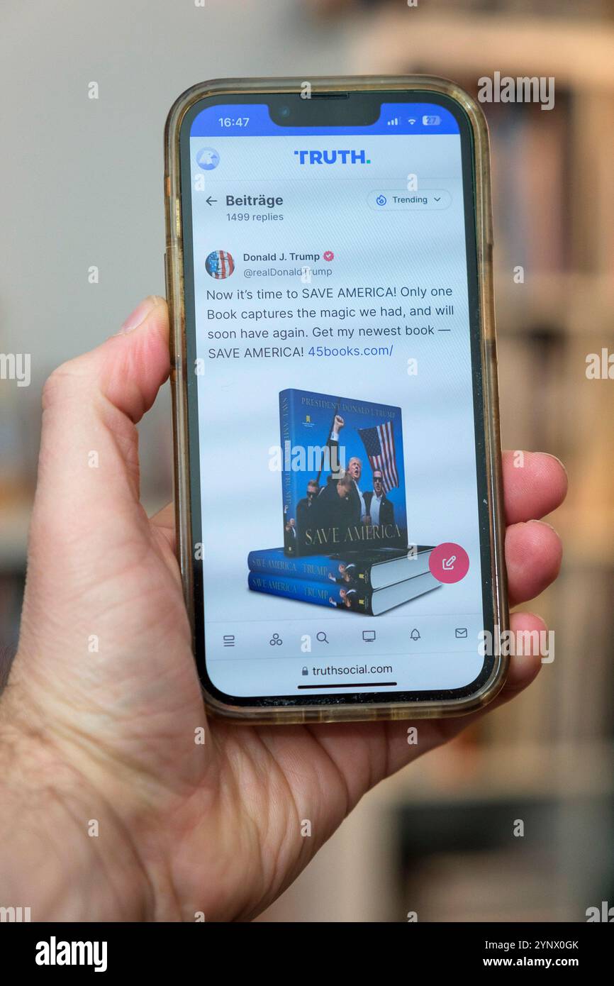 Telefono cellulare in una mano su Truth social. Truth Social è una piattaforma di social media statunitense e un sito di microblogging. Foto Stock