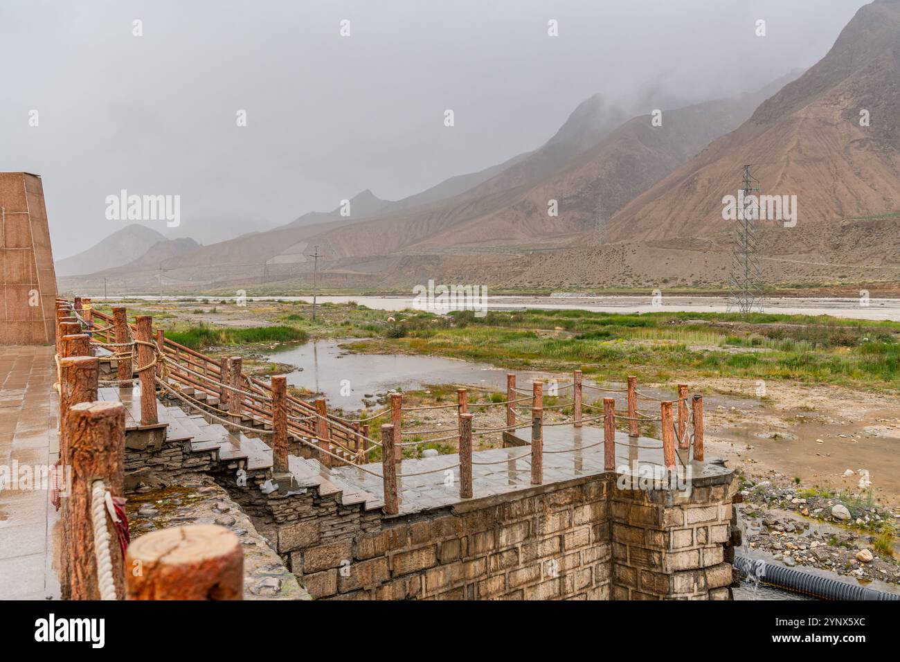 Vista sul fiume e sul passo di montagna lungo l'autostrada Tibet - Qinghai, i monti Kunlun, il tempo piovoso Foto Stock