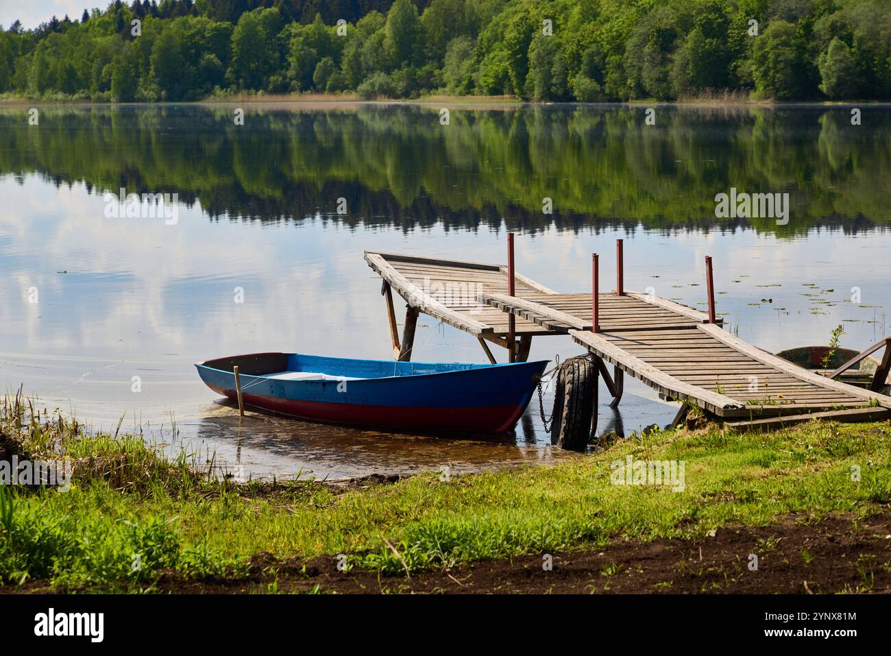 Una pittoresca e tranquilla scena lacustre caratterizzata da un'affascinante barca e un bellissimo molo Foto Stock