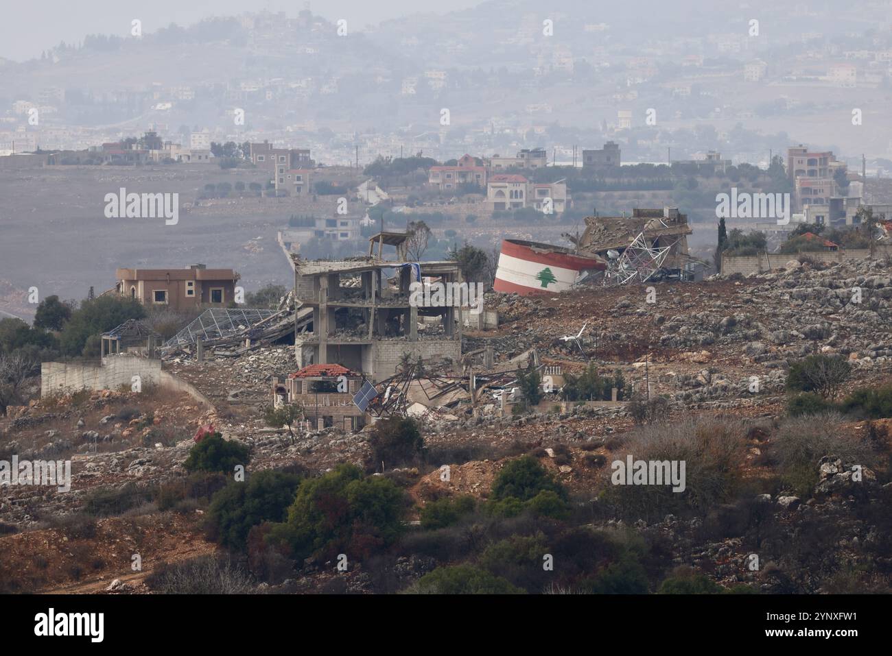 Gerusalemme. 27 novembre 2024. Questa foto scattata dal lato israeliano del confine tra Israele e Libano il 27 novembre 2024 mostra edifici distrutti nel sud del Libano. Il gabinetto di sicurezza israeliano ha approvato martedì sera un accordo di cessate il fuoco con Hezbollah, ha affermato l'Ufficio del primo Ministro israeliano in una dichiarazione. Il Kan TV News di proprietà statale di Israele ha riferito che il cessate il fuoco, mediato da Stati Uniti e Francia, avrebbe dovuto entrare in vigore mercoledì alle 4 del mattino ora locale (0200 GMT) in Israele e Libano. Crediti: Jamal Awad/Xinhua/Alamy Live News Foto Stock