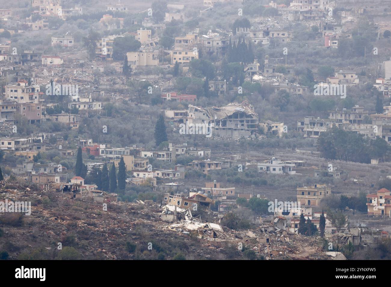 Gerusalemme. 27 novembre 2024. Questa foto scattata dal lato israeliano del confine tra Israele e Libano il 27 novembre 2024 mostra edifici distrutti nel sud del Libano. Il gabinetto di sicurezza israeliano ha approvato martedì sera un accordo di cessate il fuoco con Hezbollah, ha affermato l'Ufficio del primo Ministro israeliano in una dichiarazione. Il Kan TV News di proprietà statale di Israele ha riferito che il cessate il fuoco, mediato da Stati Uniti e Francia, avrebbe dovuto entrare in vigore mercoledì alle 4 del mattino ora locale (0200 GMT) in Israele e Libano. Crediti: Jamal Awad/Xinhua/Alamy Live News Foto Stock