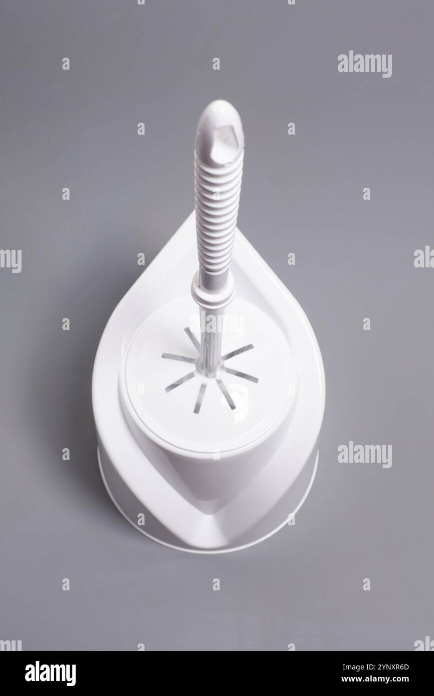 Mentre lo spazzolino del water è su sfondo grigio Foto Stock