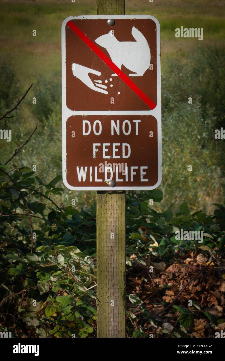Cartello "Do Not Feed Wildlife" nel paesaggio rurale su un sentiero, Oregon, Stati Uniti Foto Stock