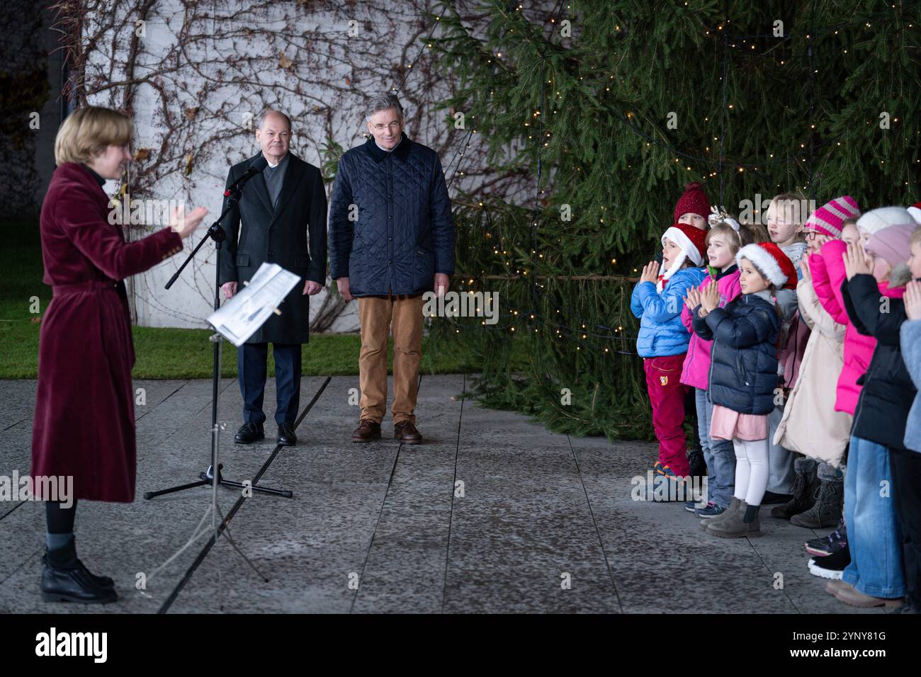 Uebergabe des Weihnachtsbaumes an den Bundeskanzler Bundeskanzler Olaf Scholz gemeinsam mit Prof. Dr. Andreas Bitter, Praesident AGDW - Die Waldeigentuemer e.V. bei dem Liedvortrag des Kinderchor der Brueder-Grimm-Grundschule bei der Uebergabe des Weihnachtsbaumes des Weihnachtsbaumes Deutschule al Cancelliere federale di Berlino del Bundeschule 11 ottobre 27.11.2024 il presidente AGDW Die Waldeigentuemer e V durante l'esecuzione della canzone del coro infantile dei Brued Foto Stock