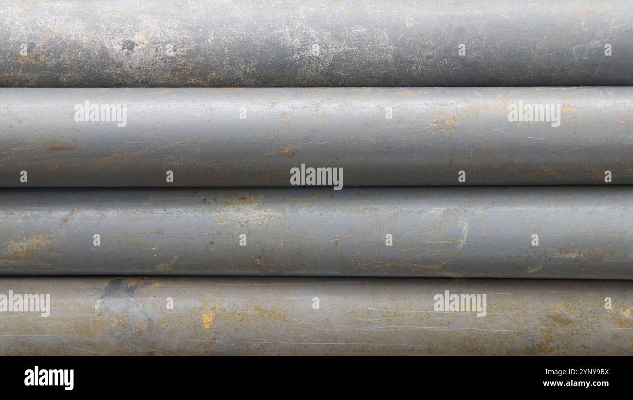 pila di vecchi tubi in pvc grigio sporchi struttura di sfondo orizzontale con superficie usurata, astratta presa dall'alto con messa a fuoco morbida Foto Stock