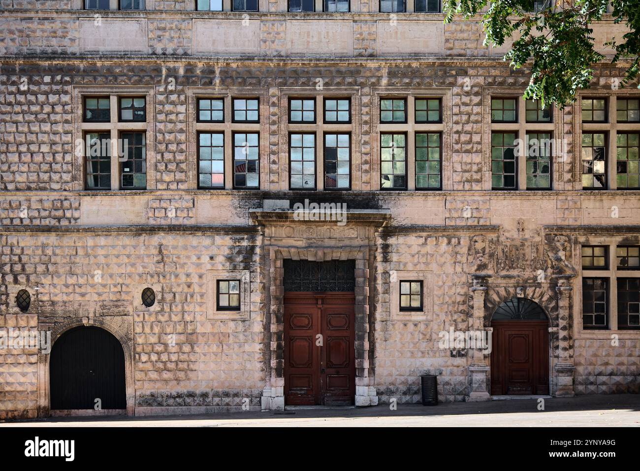 Una facciata storica di Marsiglia caratterizzata da finestre simmetriche, porte ad arco e intricati lavori in pietra, perfetta per l'architettura e i viaggi. Foto Stock