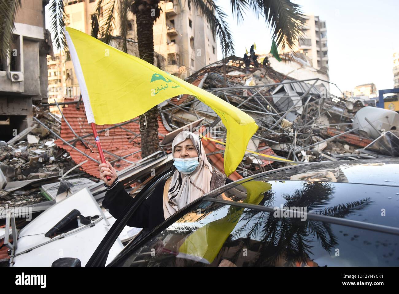 Beirut, Libano. 27 novembre 2024. I libanesi hanno issato la bandiera di Hezbollah, tenendo striscioni, restituiscono le loro case con veicoli dopo che l'accordo di cessate il fuoco tra Israele e Libano è entrato in vigore nella regione di Dahieh a Beirut, Libano, il 27 novembre 2024. Foto di FADEL ITANI/UPI. Crediti: UPI/Alamy Live News Foto Stock