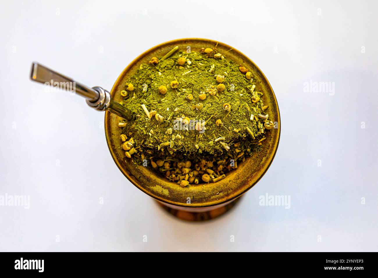 Tradizionale chimarrão brasiliano servito in una buccia con fiori di camomilla Foto Stock