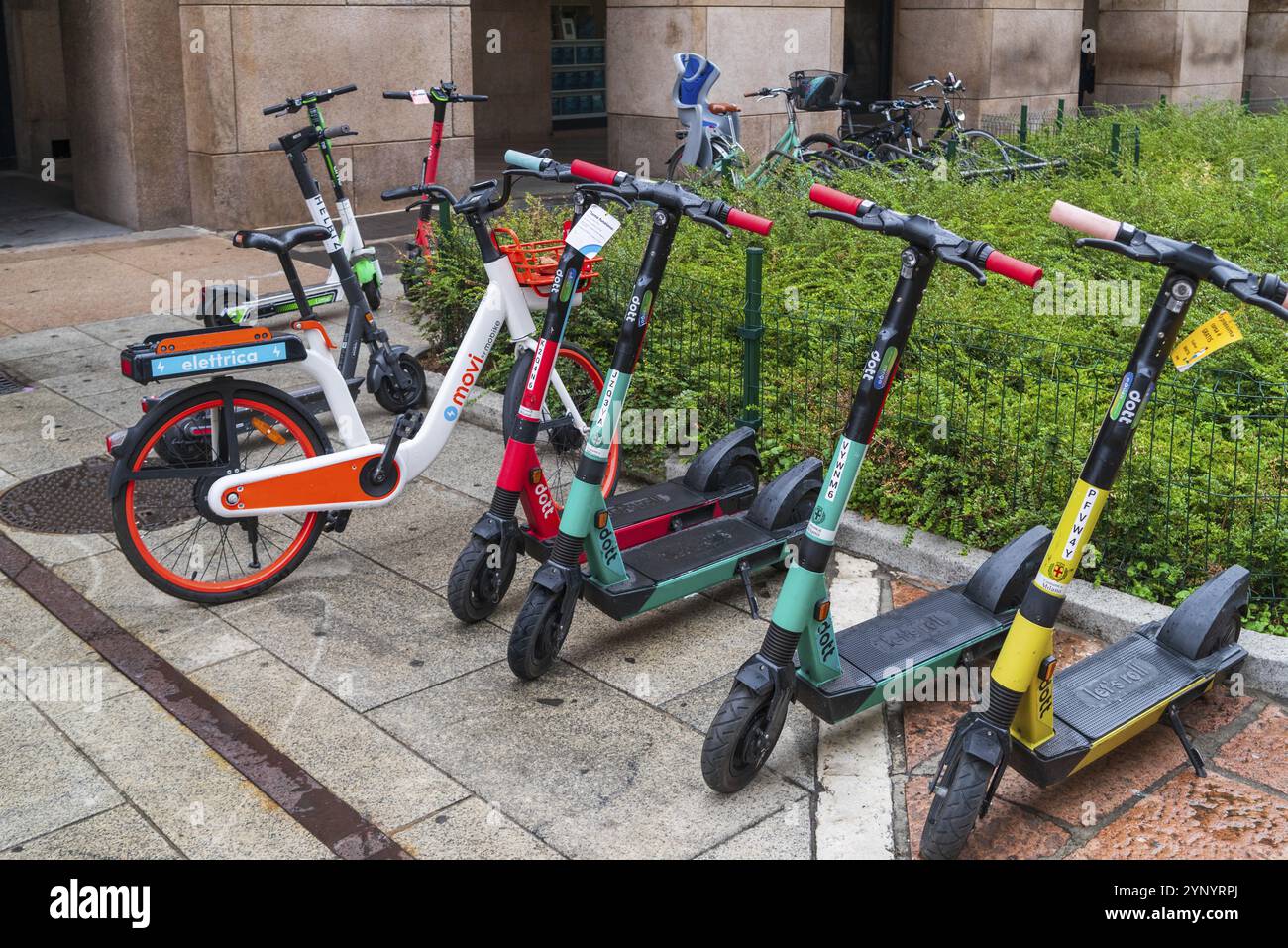 MILANO, ITALIA, 4 AGOSTO 2021: Noleggio di scooter e biciclette colorati su un marciapiede nel centro di Milano Foto Stock