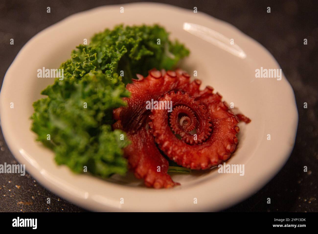 Octopus Sashimi arrotolato in un ramekin Foto Stock