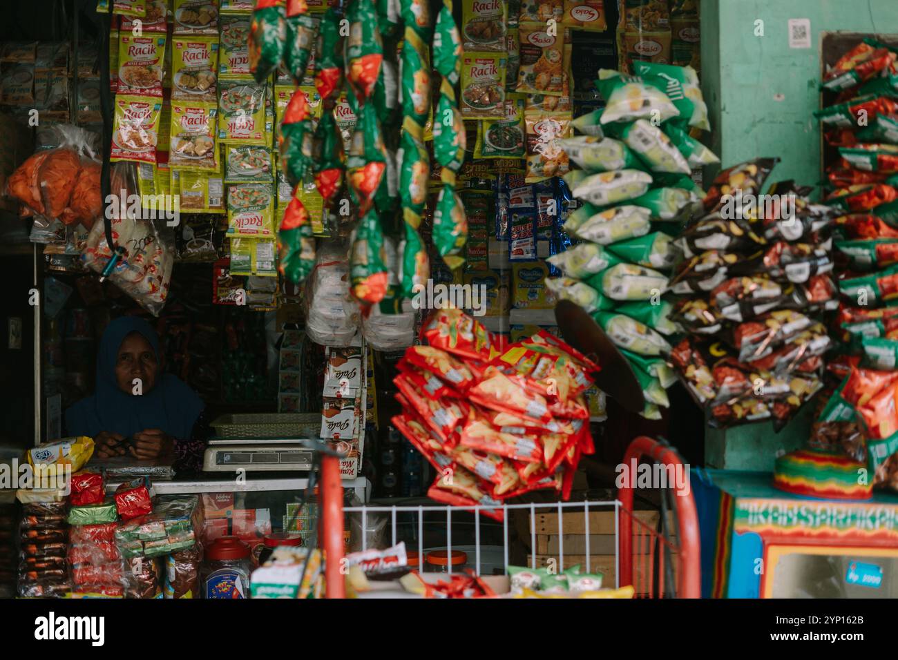 Depok, 24 novembre 2024. Piccolo minimarket che offre una varietà di spuntini e dolcetti. Ideale per i temi dei mercati locali, dello Street food o di tutti i giorni Foto Stock