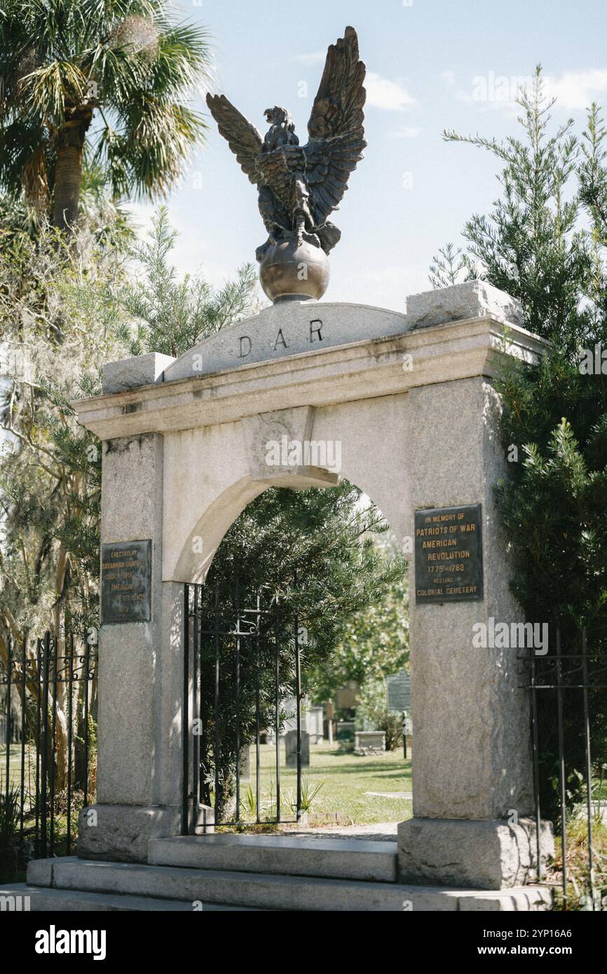 Ingresso allo storico Colonial Park Cemetery nel centro di Savannah, Georgia, caratterizzato da un'entrata ornata in ferro incorniciata da muschio e alberi spagnoli Foto Stock