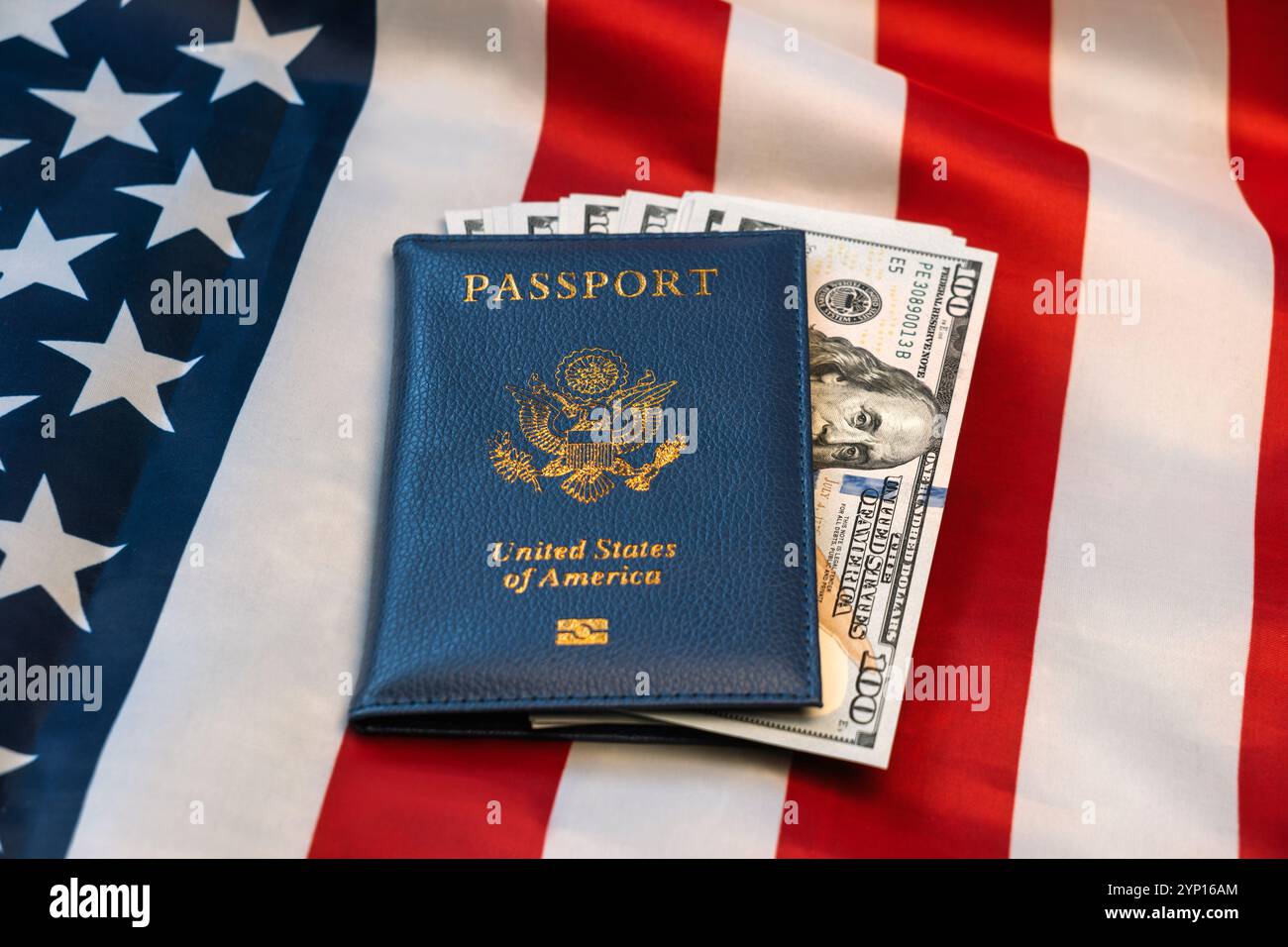 Passaporto degli Stati Uniti con molte banconote in dollari USA e con le stelle e le strisce. concetto di cittadinanza o di viaggio Foto Stock