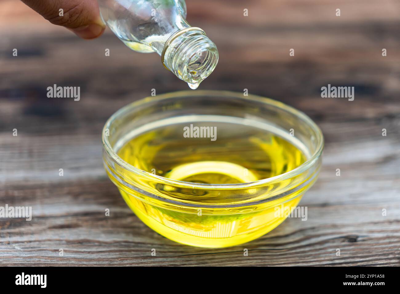 Caraffa in vetro con olio su fondo di legno scuro Foto Stock