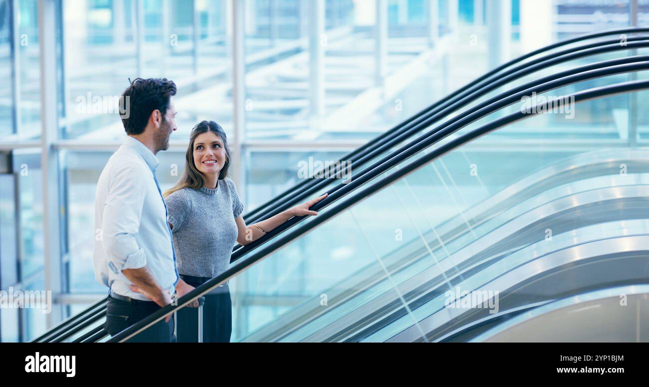 Persone d'affari, scale mobili e viaggi all'aeroporto con bagagli per voli, viaggi internazionali e chiacchiere. Viaggio di squadra, lavoratori felici e valigia Foto Stock