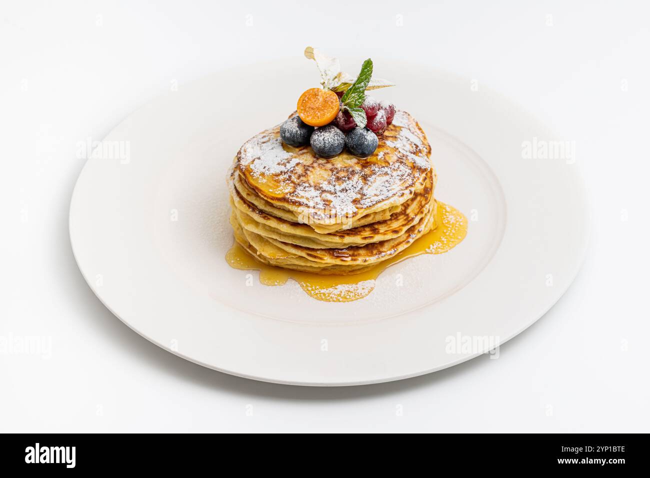 Pancake con frutta e sciroppo d'acero su un piatto bianco Foto Stock