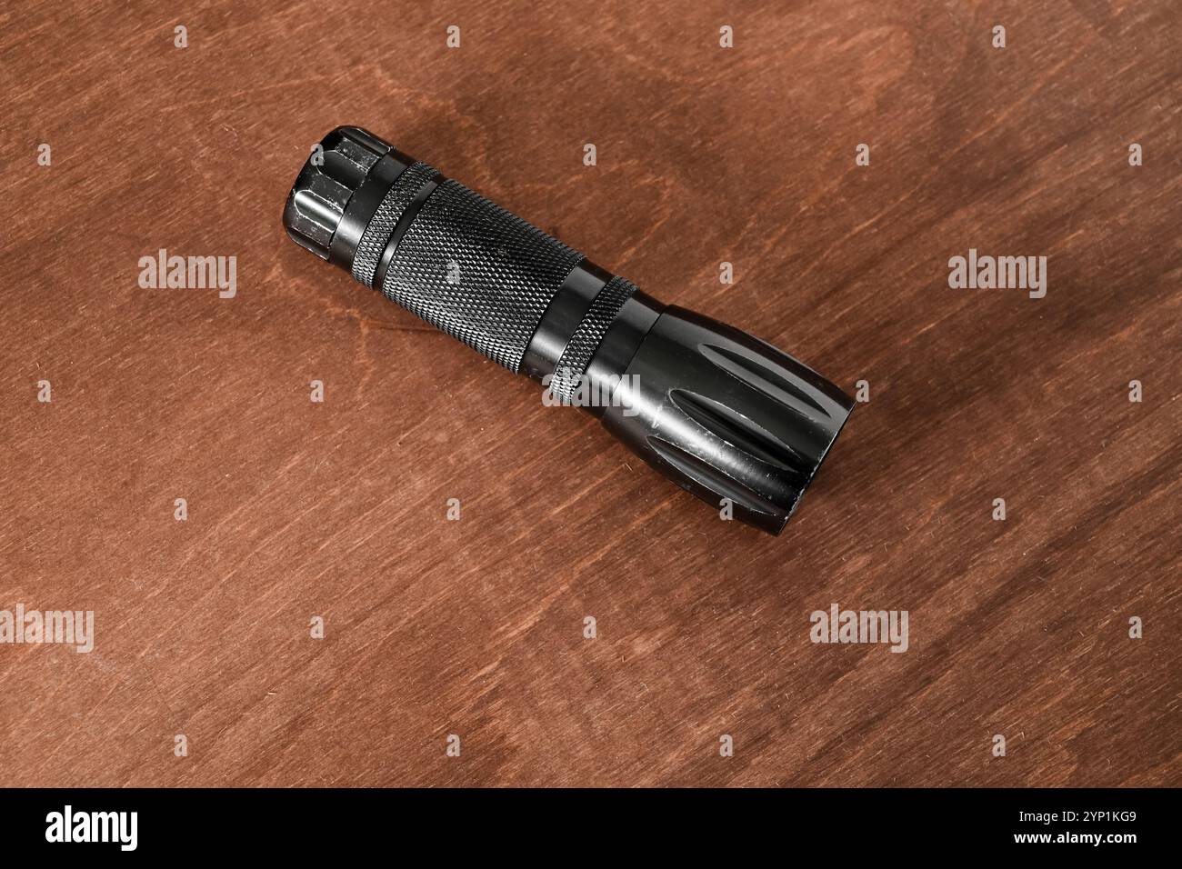 piccola ma potente torcia o torcia elettrica ben usata su un tavolo in legno Foto Stock