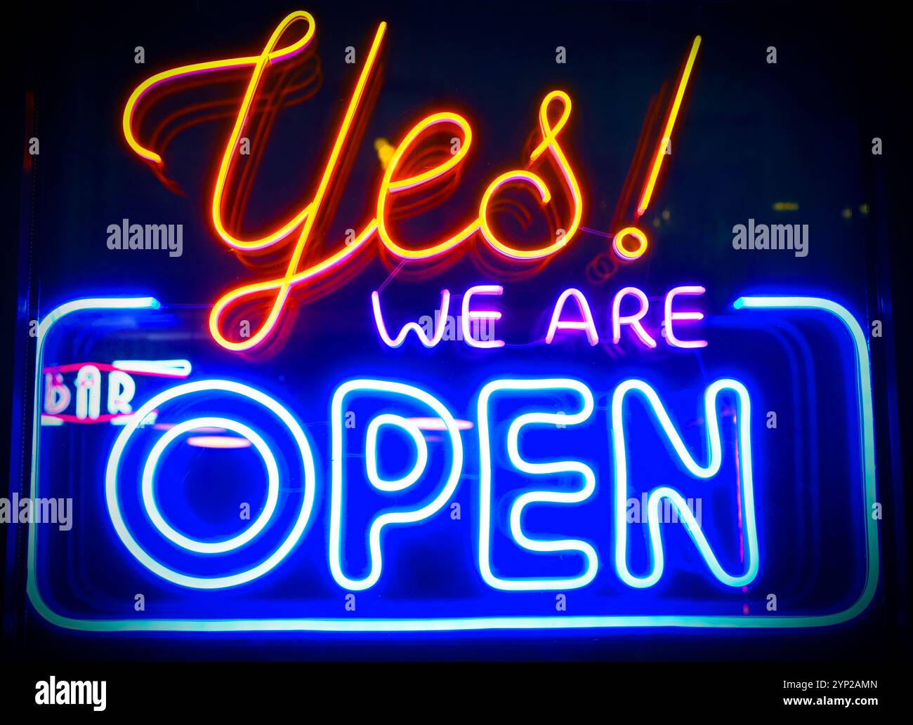Sì, siamo aperti - cartellone al neon luminoso sulla finestra di vetro durante la notte Foto Stock