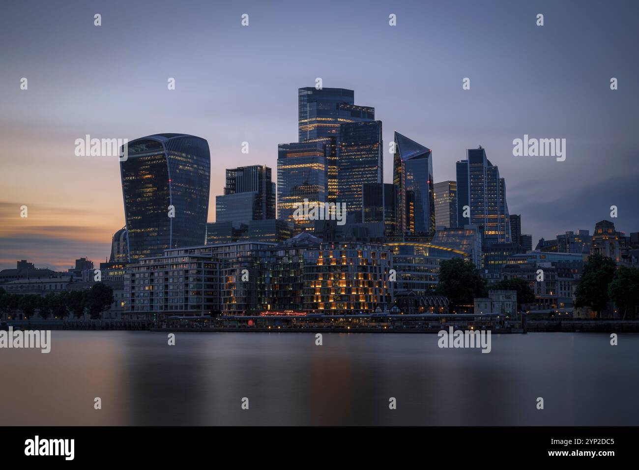 Mentre il sole tramonta sulla città di Londra, il paesaggio della città si anima con le luci scintillanti dei grattacieli. Foto Stock