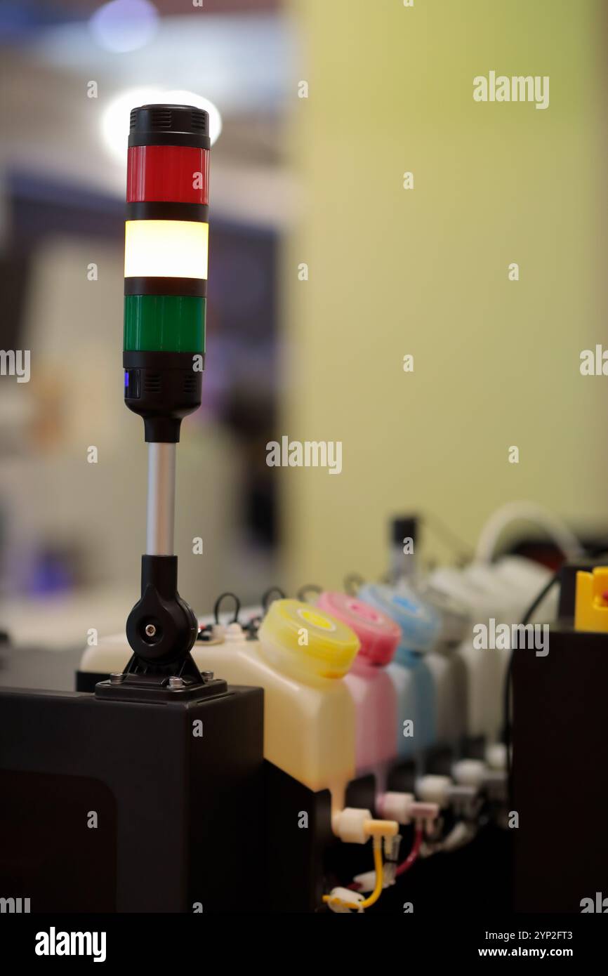 Torrette di segnalazione industriali montate su stampanti a getto d'inchiostro per grandi formati. Spie luminose a LED. Messa a fuoco selettiva. Foto Stock