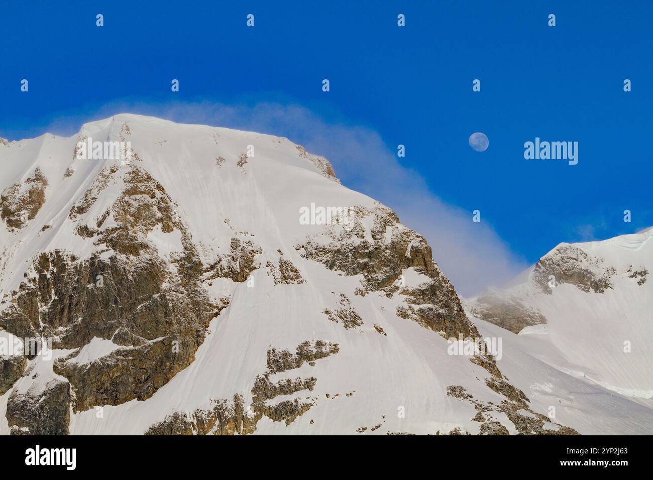 Vista della luna quasi piena che si innalza sulle montagne innevate della Penisola Antartica, Antartide, regioni polari Foto Stock