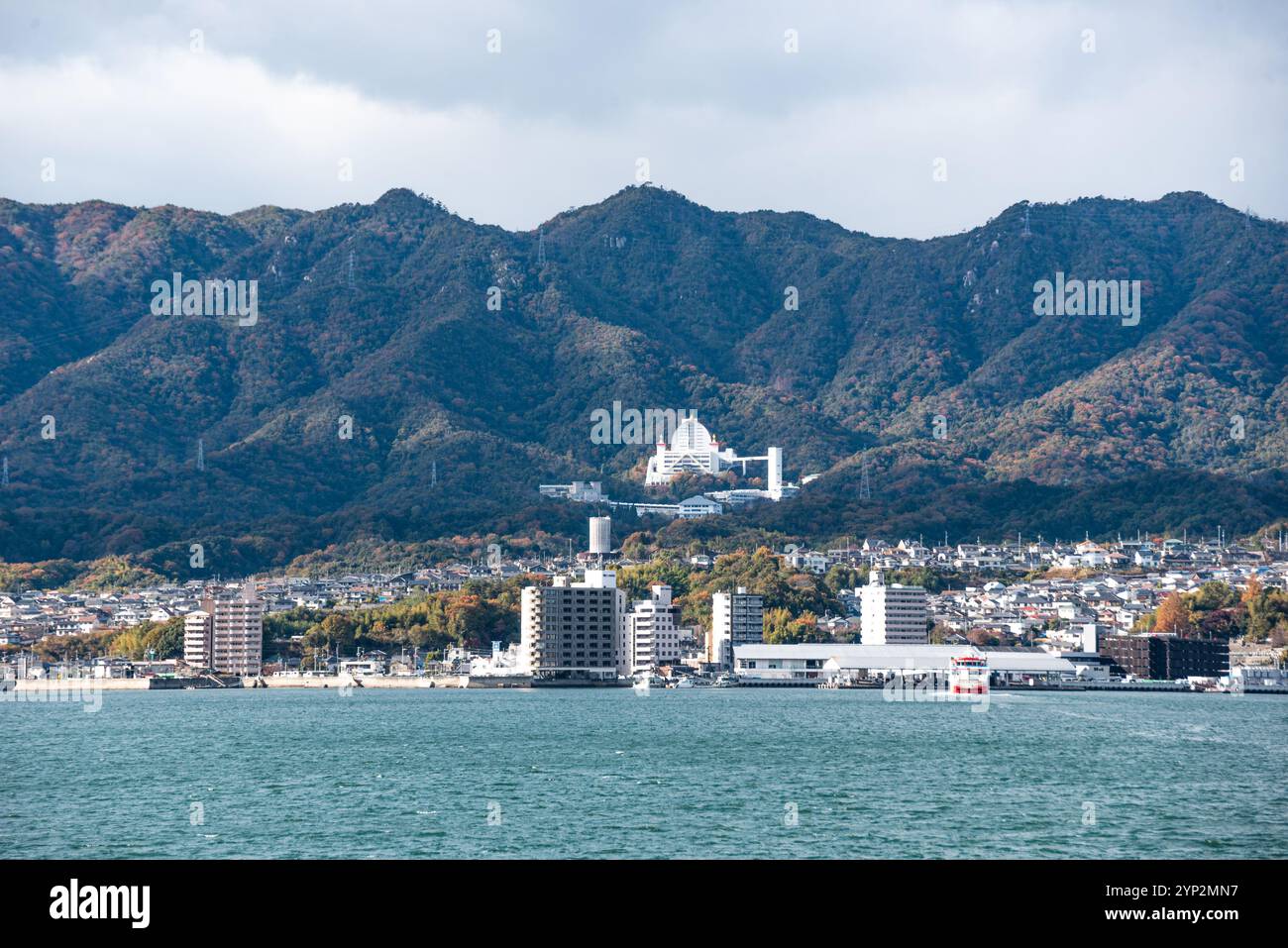 Città ai piedi di una montagna sul mare interno, Miyajima, Prefettura di Hiroshima, Honshu, Giappone, Asia Foto Stock